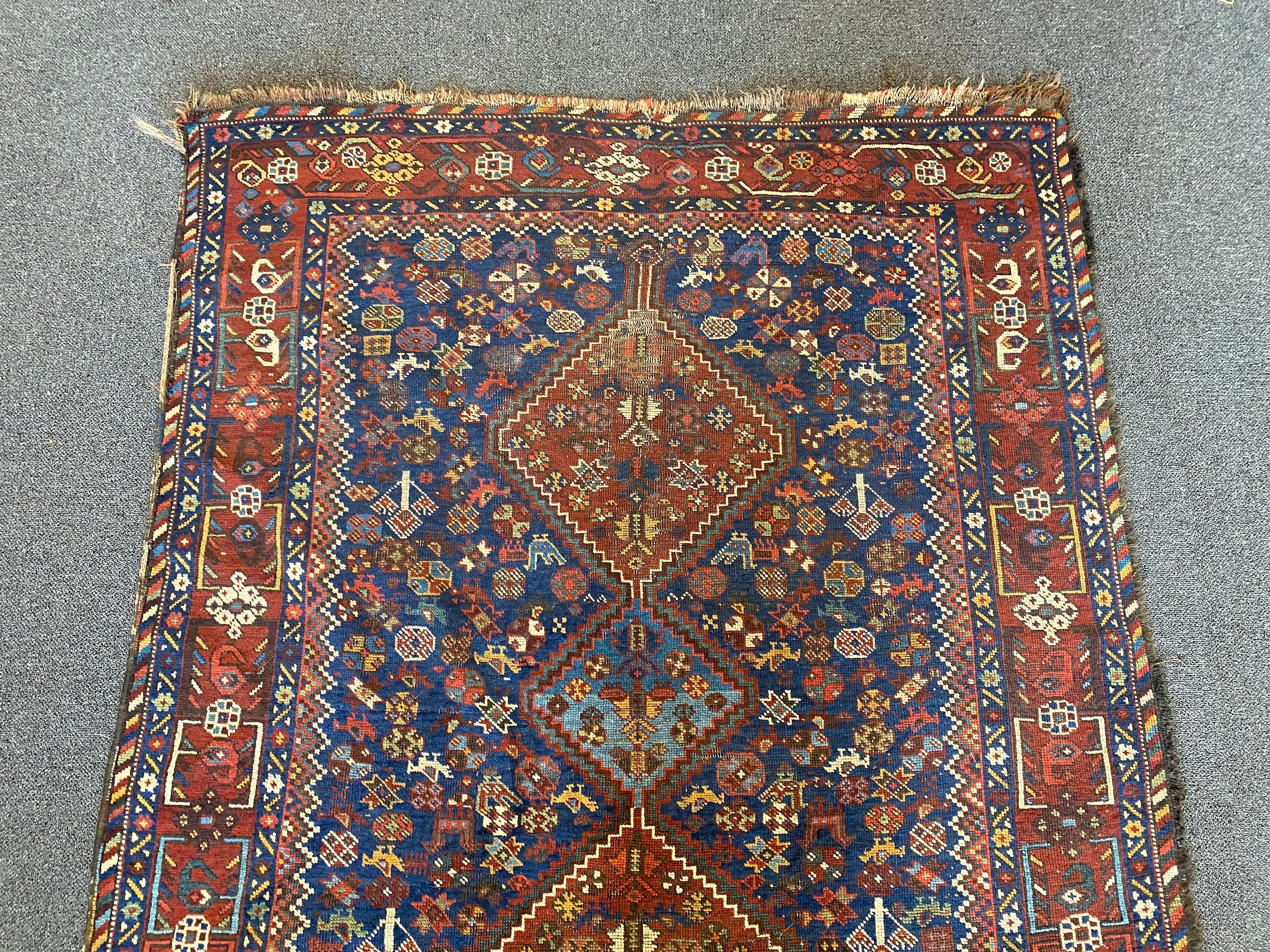 A Shiraz blue ground rug with triple lozenge medallion and floral border 160 x 122 cms.